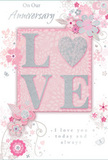 In this image, a softly romantic anniversary card is presented in close view, its design a gentle celebration of enduring love. The card's palette leans into pastel pinks and silvery greys, with a powdery softness reminiscent of an early spring sky over Bexleyheath's residential streets. At the centre, the word LOVE is formed in raised lettering, the surface dusted with fine, pale glitter so the letters shimmer rather than sparkle boldly. The O is imaginatively replaced by a silver-toned, textured heart, creating a subtle focal point that draws the eye and adds a sense of affection and intimacy. Surrounding this word, clusters of delicate blooms in blush, mauve, and soft ivory unfold across the background, their edges lightly feathered to suggest watercolour brushstrokes. Slim, flowing lines extend from each blossom like vines or trailing stems, giving the sense of a loosely gathered bouquet spreading gracefully across the card. Small decorative touches-tiny petals, curving swirls, and discreet butterflies-are dotted here and there, hinting at movement, as though a light wind had just passed over a garden. The text On Our Anniversary and I love you today and always appears in an understated, carefully chosen script, the letters slightly slanted and elegant, echoing the natural curves of the illustrated stems. The overall layout is balanced and uncluttered, allowing space for the design to breathe while maintaining a cosy, intimate feel. This card would pair perfectly with a pastel anniversary arrangement delivered to a doorstep in Bexleyheath, carrying a message that is soft-spoken yet deeply heartfelt, like a quiet promise renewed year after year.
